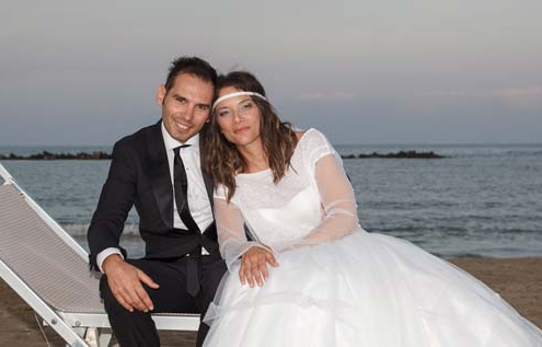 Sposi seduti sul lettino in riva al mare