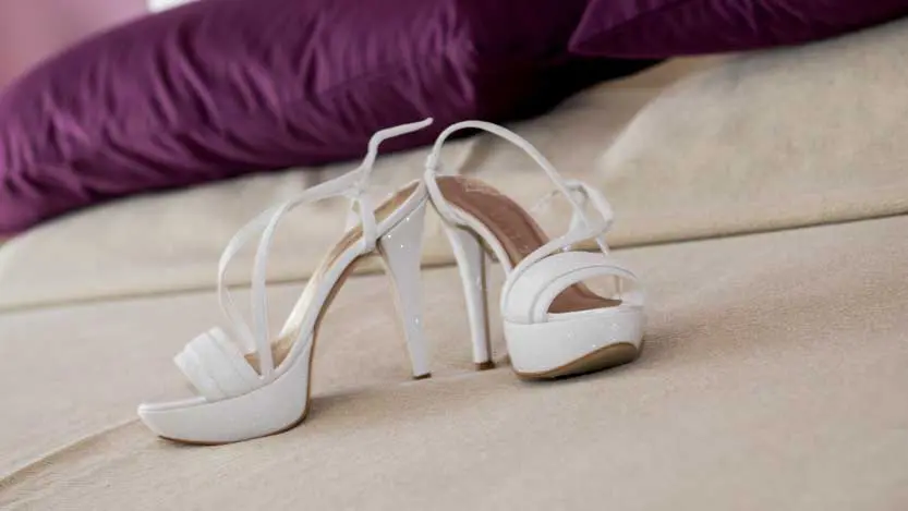 Still life di scarpe della sposa sul letto