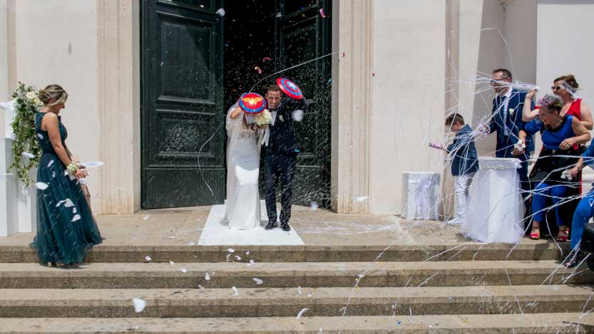 Sposi mentre escono dalla Chiesa con scudi da super eroi