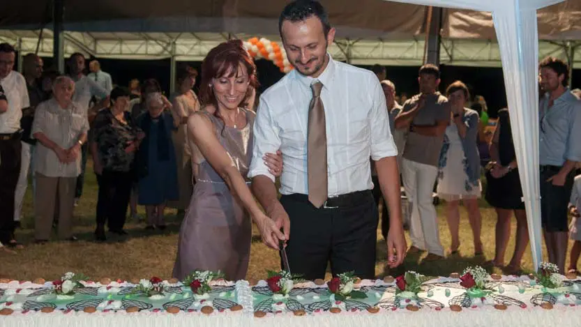 Fotografo matrimonio di Katia e Ivan mentre stanno tagliando la torta nuziale sotto un gazebo