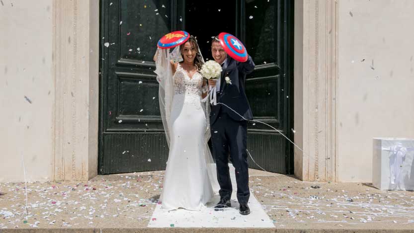 Immagini divertenti matrimonio sposi all'uscita della chiesa con gli scudi