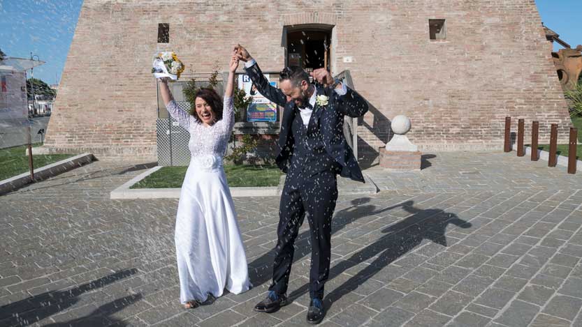 Fotoreportage di matrimonio sposi inondati dal riso