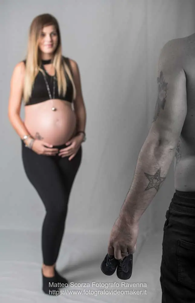 mamma in cinta sfuocata osserva le scarpine del bimbo