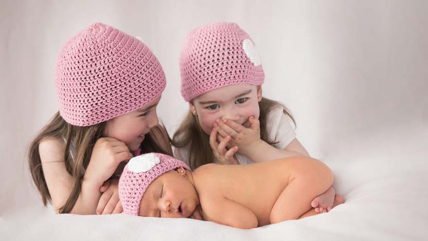 Foto neonati sorelline gemelle sorridono alla neonata