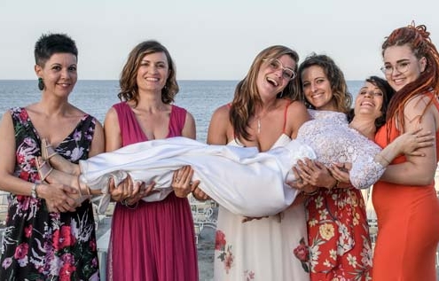 Matrimonio-sulla-spiaggia-amiche-tengono-in-braccio-la-sposa