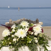 Tavolino con fiori per rito nuziale in spiaggia