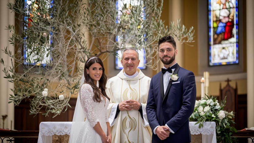 Sposi con sacerdote con ulivo sullo sfondo