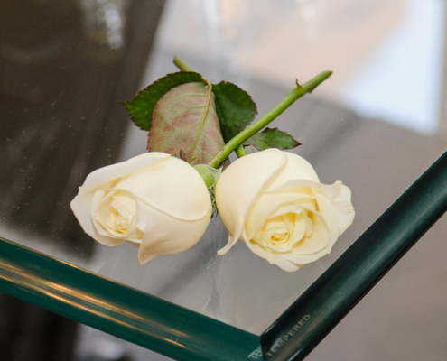 Rose bianche su tavolo di cristallo