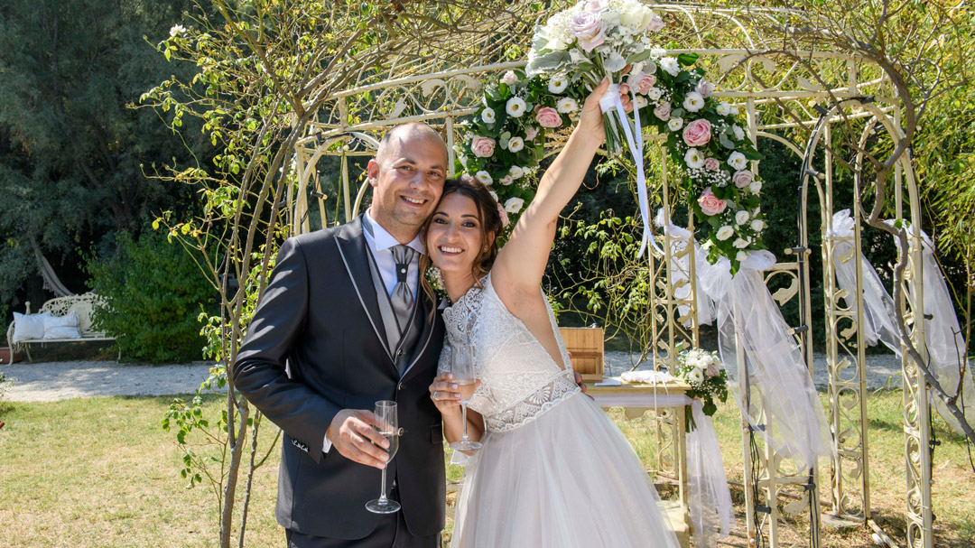 Sposi-sorridenti-davanti-ad-arco-di-rose