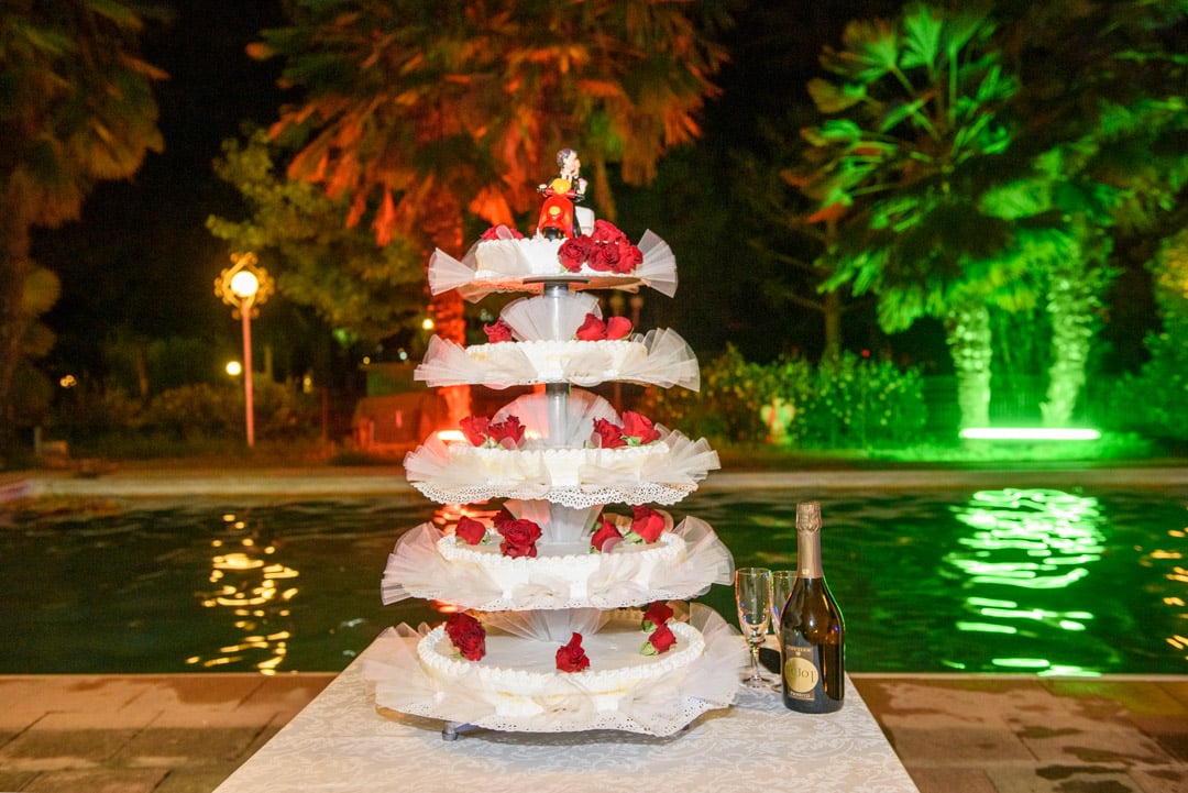 Torta nuziale a bordo piscina con luci colorate