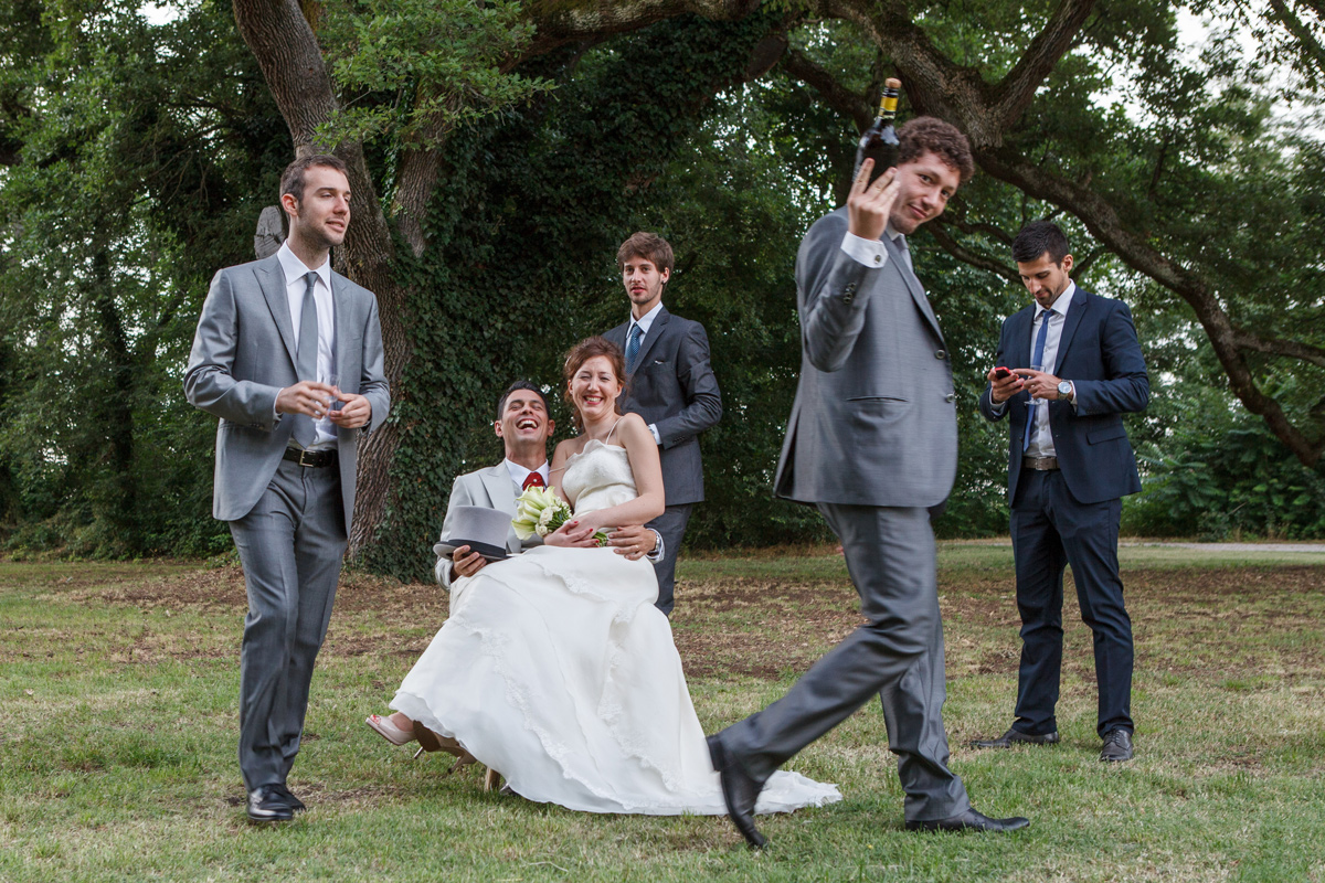 Villa Isolani, sposa e sposo abbracciati e sorridenti sotto il grande bosco di querce secolari nel parco.