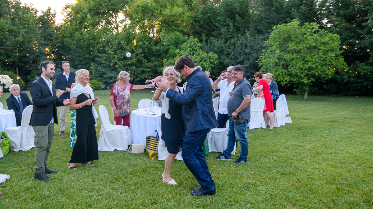 Villa Rosa Camerlona Ravenna: sposo che balla con un'invitata sul prato tra i tavoli del ricevimento all'aperto
