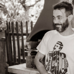 Sposo sorridente appongiato al palo